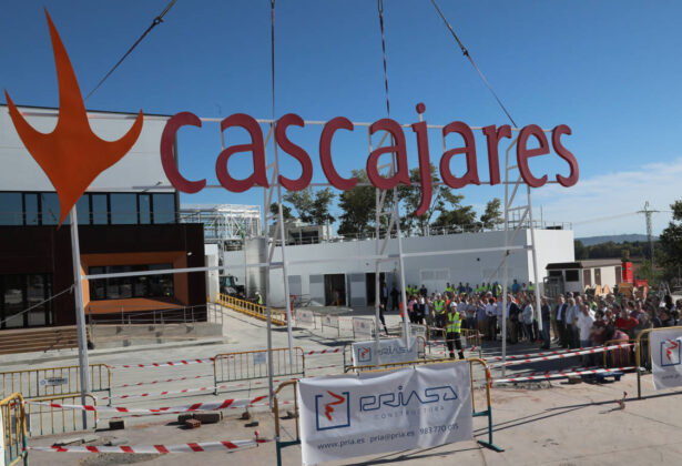 Responsables y trabajadores de Cascajares y de las empresas constructoras junto al cartel de Cascajares que sobrevivi&oacute; al incendio y que se ha vuelto a recolocar en las nuevas instalaciones. / Br&aacute;gimo (ICAL)