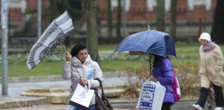 Temporal de viento y lluvia en Palencia. En la imagen unas mujeres sortean el agua y el viento en la plaza de la Pio XII de Palencia. / Brágimo (ICAL)