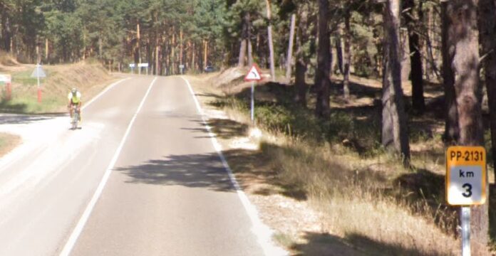 Un ciclista transita por la carretera que une Aguilar de Campoo con la Playa del Pantano de Aguilar.