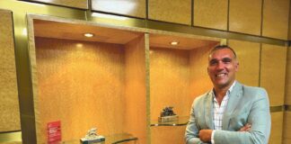 Juan José Ramos posa junto a los reconocimientos y premios recibidos por su agencia J&J Seguros Generali