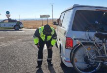 Un agente de tráfico controla el estado del neumático de una furgocamper francesa en la N-610.