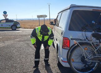 Un agente de tráfico controla el estado del neumático de una furgocamper francesa en la N-610.