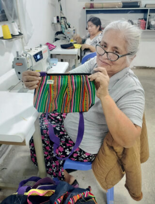 Un mujer peruana muestra unos de los bolsos elaborados en un taller de Paita, regi&oacute;n de Piura de Per&uacute; y que se comercializan en la tienda Vida propia de Guardo (Palencia)