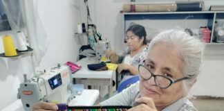 Un mujer peruana muestra unos de los bolsos elaborados en un taller de Paita, región de Piura de Perú y que se comercializan en la tienda Vida propia de Guardo (Palencia)