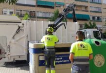 Operarios de Palencia Deslumbra recogiendo esta tarde los contenedores de cartón en la zona de Cardenal Cisneros. / Óscar Herrero