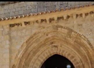 El abad Reinoso, representado como figura gigante, sale de la iglesia de Husillos para iniciar el pasacalles